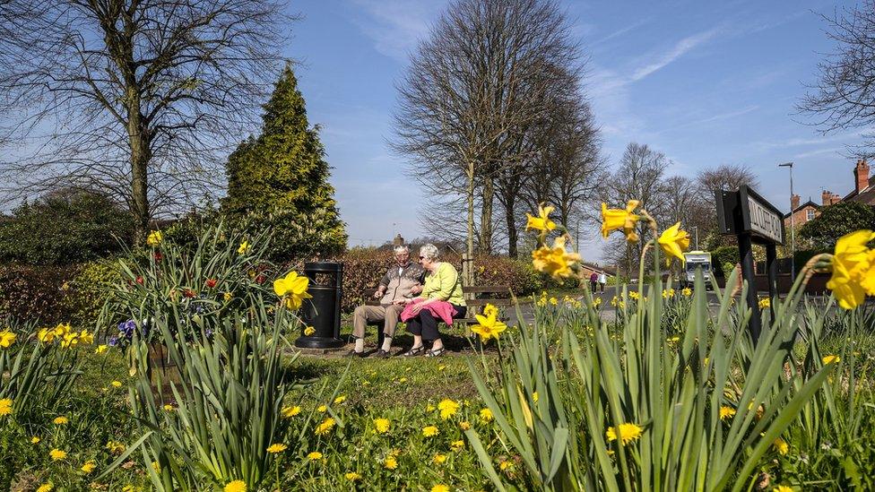 A couple sit on a bench in Stockton Heath in Cheshire