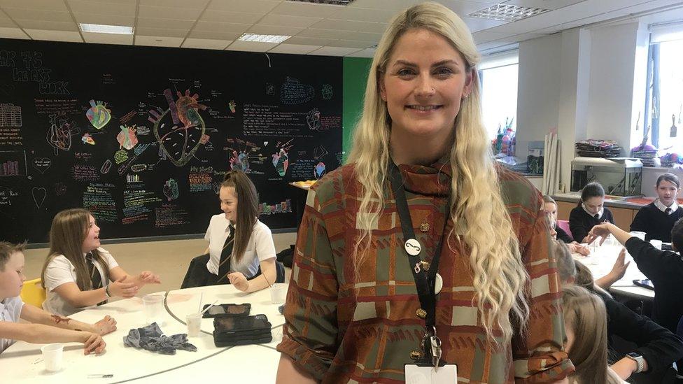 Teacher Penny Pearson with artistic drawings of a heart behind her