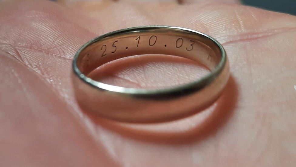 A wedding ring on the palm of a hand