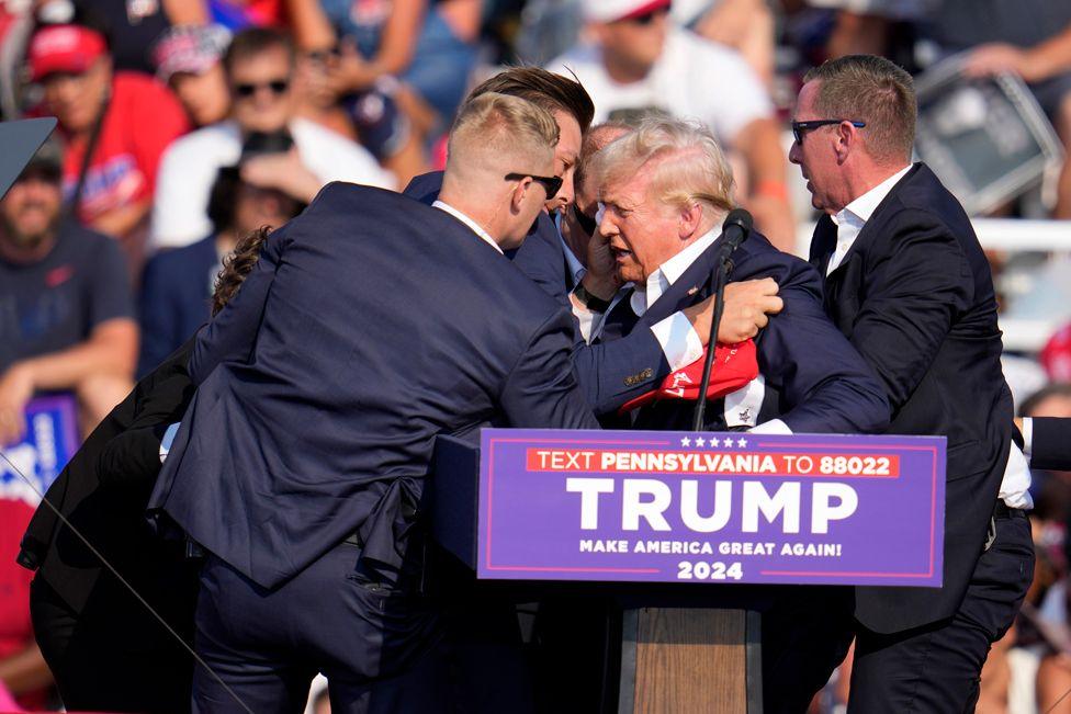 Republican presidential candidate former President Donald Trump is helped off the stage at a campaign event in Butler, Pa., on Saturday, July 13, 2024.