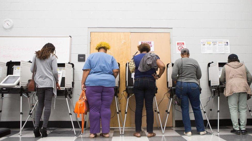 Georgia voters cast a ballot at the polls as part of the state's early voting initiative.