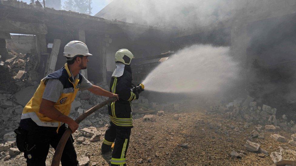 Syrian firefighters try put out a fire in a building that was hit by reported Russian air strikes in the rebel-hold town of Jadraya, about 35km south-west of the city of Idlib, on September 4, 2018