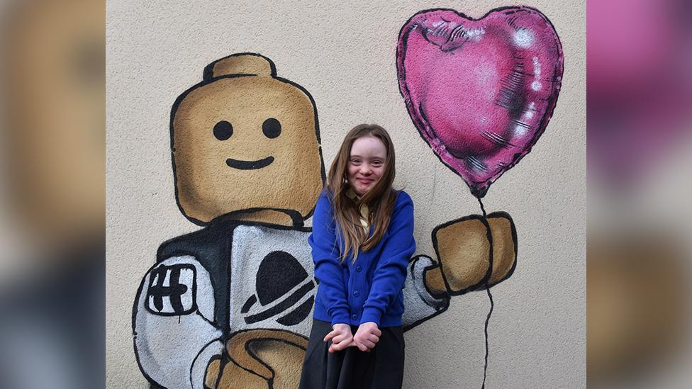 Hollie Evans in front of Lego man artwork