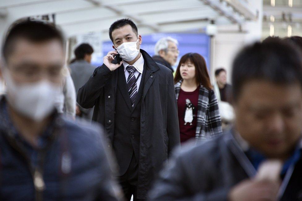 A man walks wearing a mask in Yokohama, near Tokyo, Japan, 26 February 2016