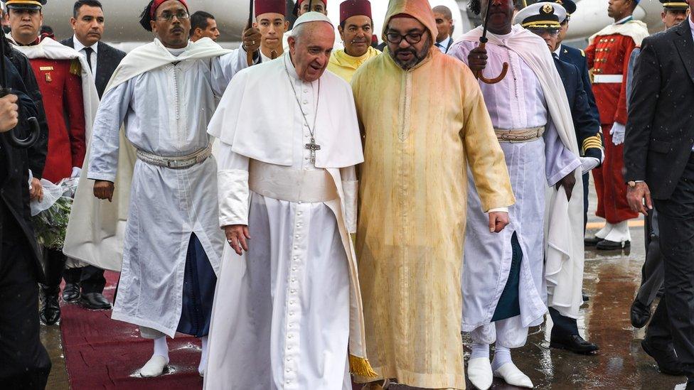 Pope Francis is received by Morocco's King Mohammed VI upon disembarking from his plane at Rabat-Sale International Airport