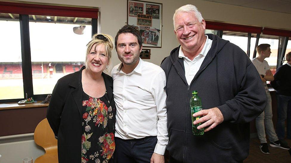 George Gilbey, Linda Gilbey and Pete McGarry standing together. A woman on the left a young man standing in the middle and a man in his late 60s or early 70s standing on the right. Everyone is smiling.