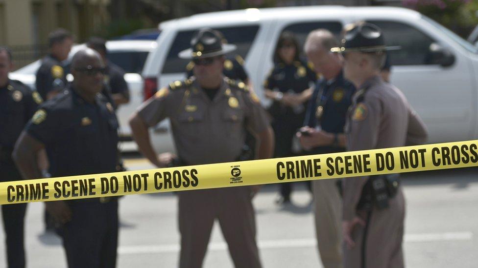 Police stand behind a crime scene tape near the mass shooting at the Pulse nightclub on in Orlando, Florida on June 12, 2016