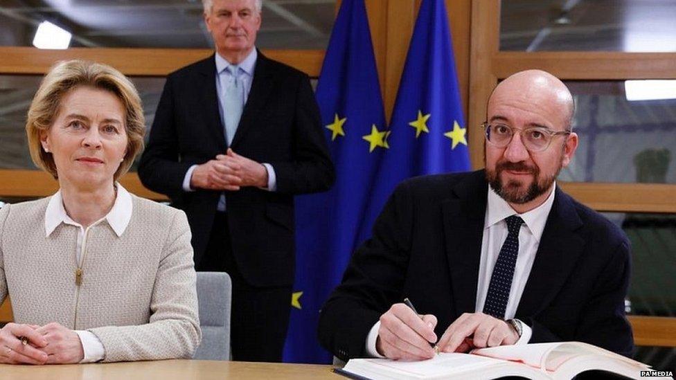 Charles Michel and Ursula von der Leyen sign the UK's withdrawal agreement, watched by chief negotiator Michel Barnier