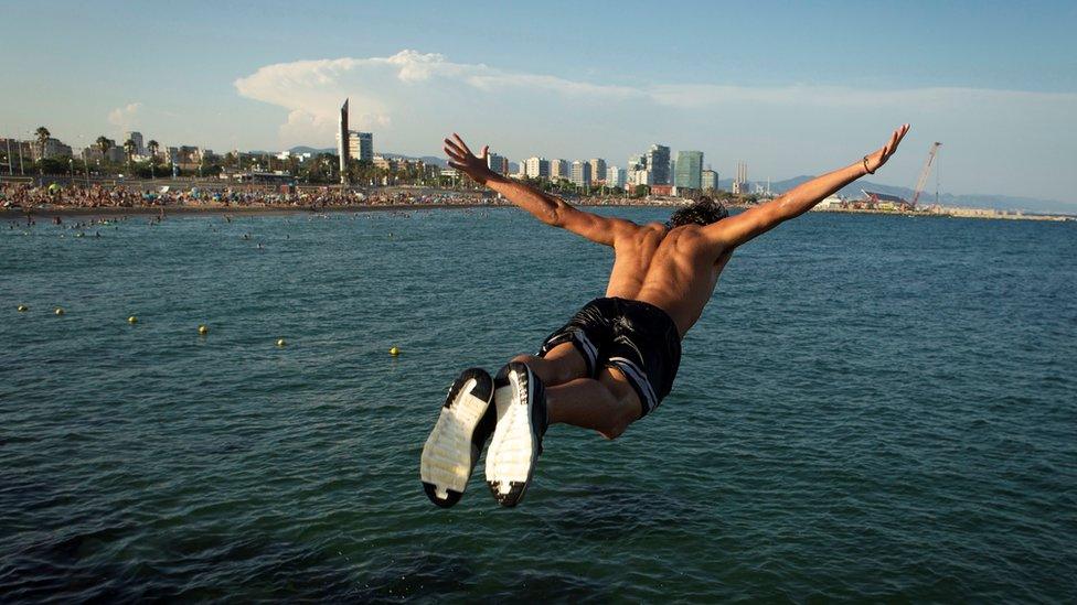 People jump into water in Barcelona, Spain