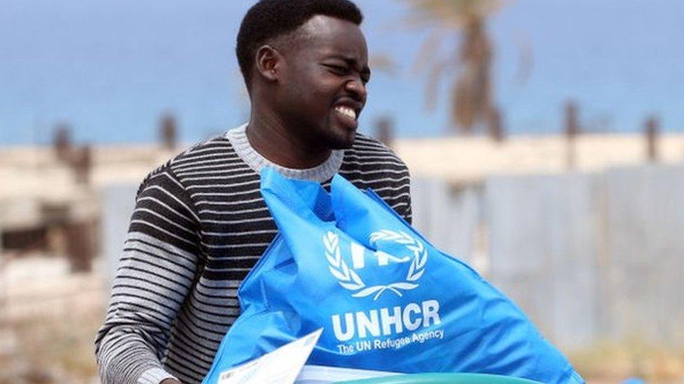 A man caries a bowl with aid items at a United Nations' High Commissioner for Refugees (UNHCR) camp for displaced Libyans and asylum seekers, on May 12, 2020 in the Libyan capital Tripoli during the Muslim holy month of Ramadan.