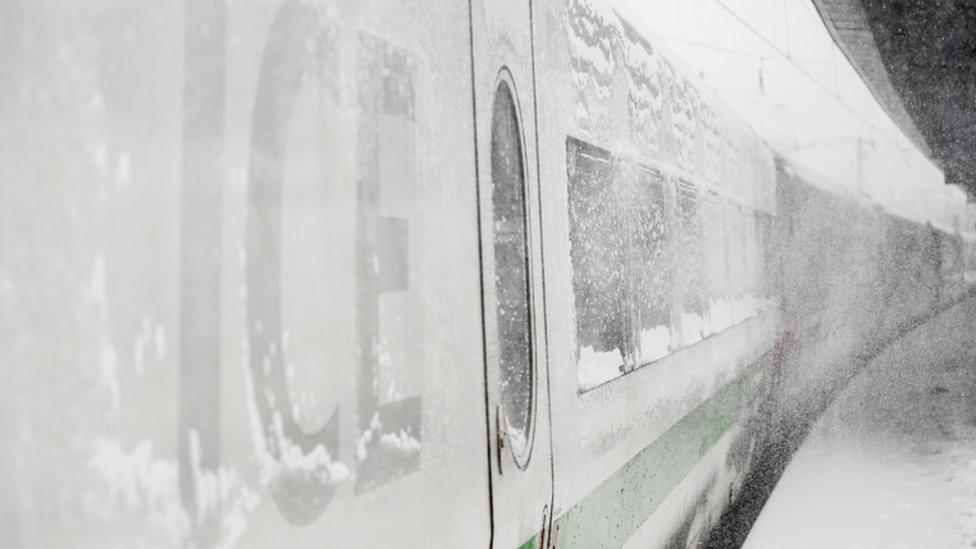 An ICE high-speed train is seen covered in snow at the main train station in Dortmund, Germany