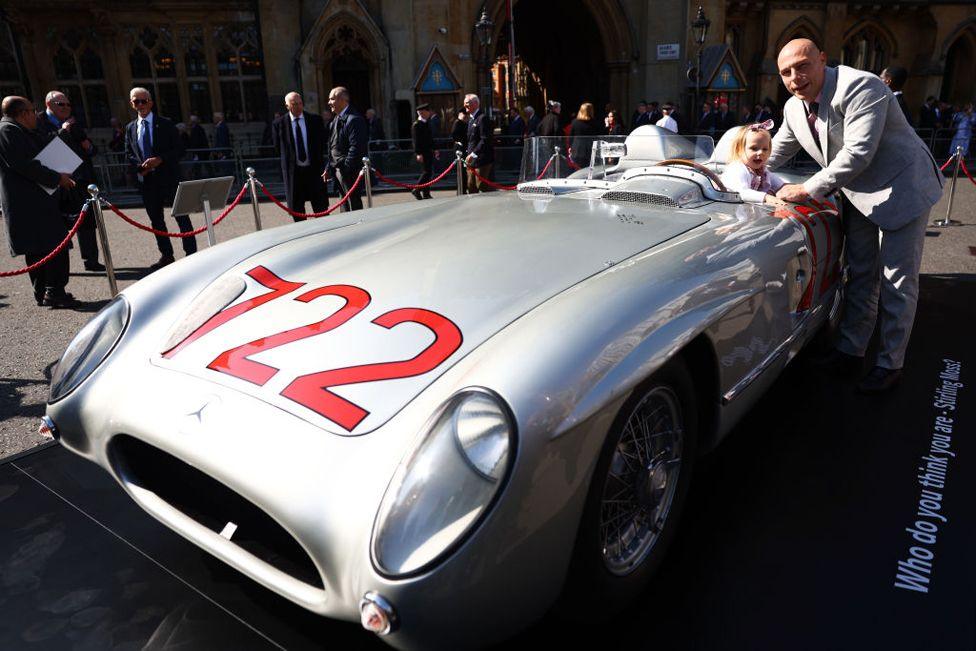 Elliot Moss with his daughter Stephanie pose beside vintage race car in London