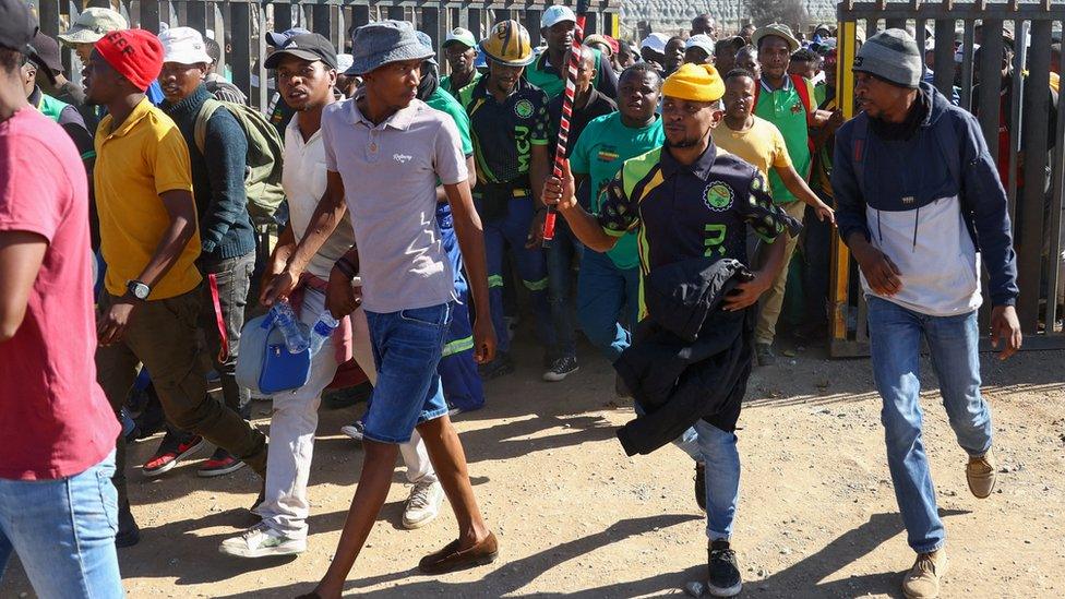 Some of the more than 500 South African mine workers who have been underground since Sunday night react after emerging at Gold One's Modder East mine, in Springs, east of Johannesburg, South Africa, October 25, 2023.