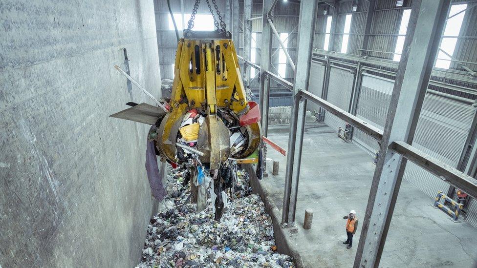 A grabber takes the waste and empties it into a hopper