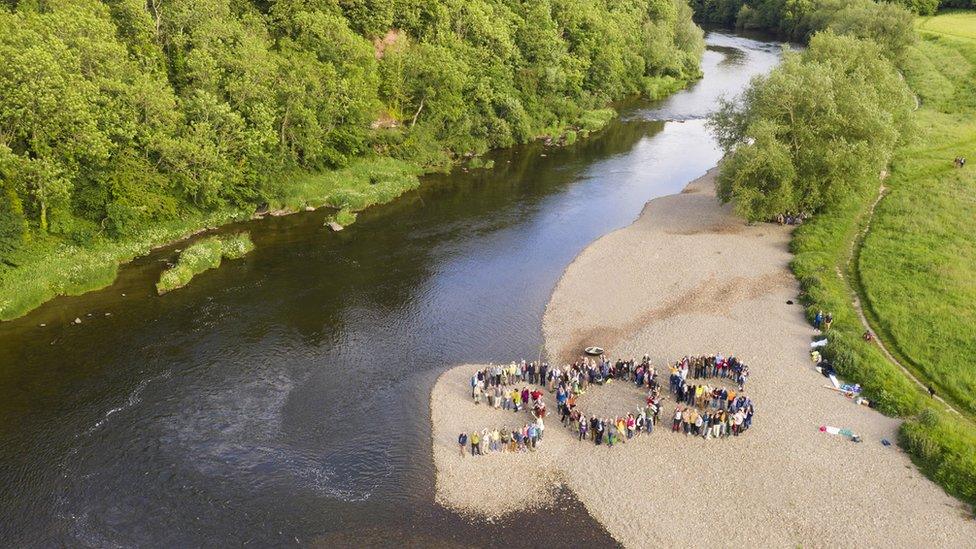 Aerial shot of people stood in formation to spell out SOS