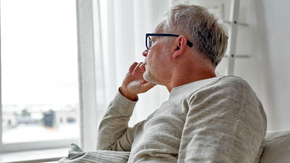 Man sitting and staring out of window