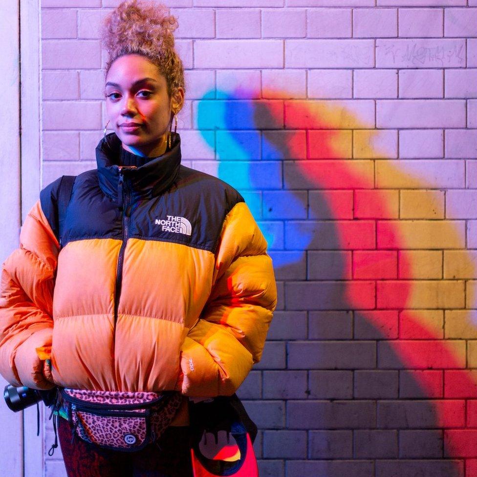 A woman standing by a wall