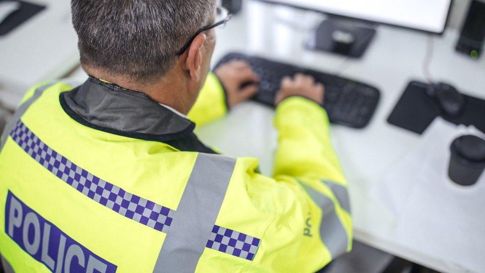 Police officer at laptop