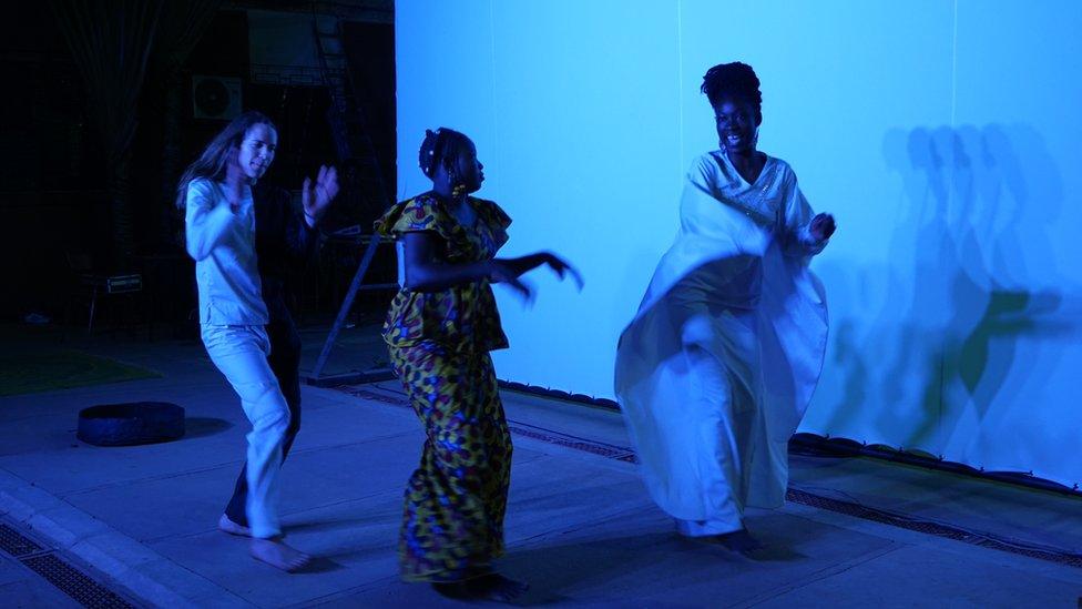 Franco-Swiss dancer Nina Berclaz, Hadiako Sanou (wife of Maboudou) and Latifatou Ouédraogo dance during a rehearsal on the eve of the premiere of the first act of Là-bas ou Ici (Here or There) at the Institut Français in Ouagadougou on April 22, 2021.