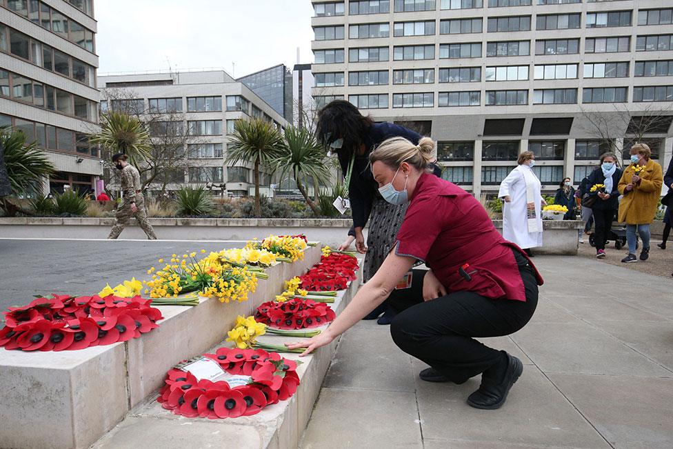 Members of staff place flowers outside St Thomas' Hospital