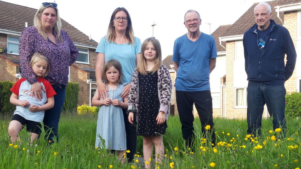 Residents gathered in long grass