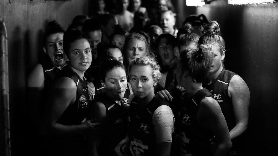 Carlton players, led by captain Lauren Arnell, gather to enter the ground