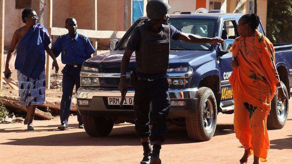 Malian security forces evacuate two women from an area surrounding the Radisson Blu hotel in Bamako