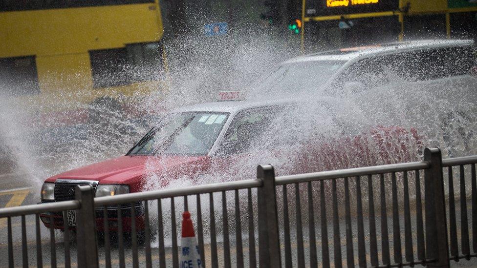 A cab drives through heavy rain in Hong Kong