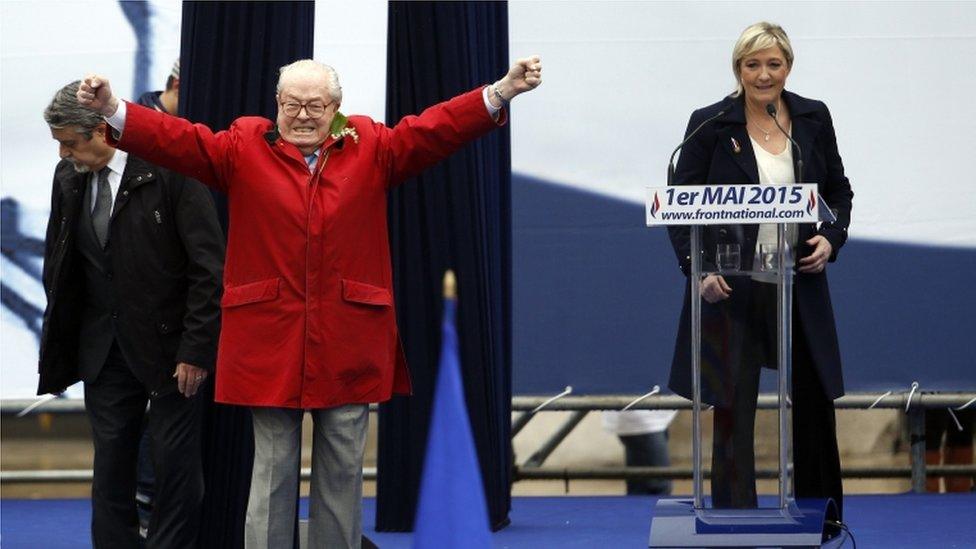 Jean-Marie Le Pen gestures on stage alongside Marine Le Pen