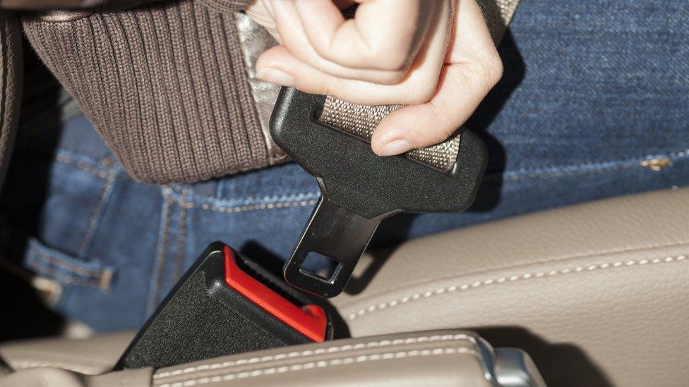 Woman doing up seat belt