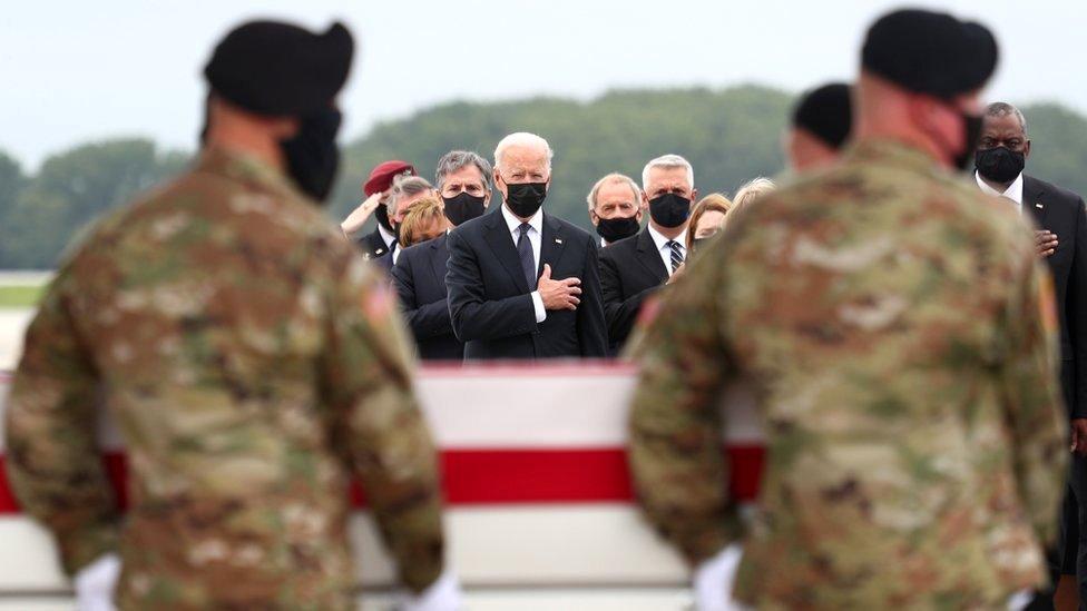 US President Joe Biden salutes during the dignified transfer of the remains of US Military service members who were killed by a suicide bombing at the Hamid Karzai International Airport, at Dover Air Force Base in Dover, Delaware