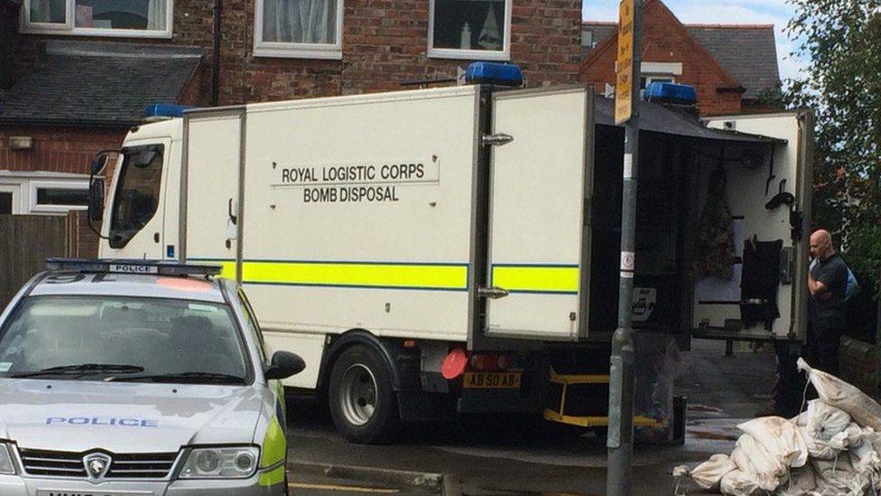 Officer standing next to bomb disposal lorry