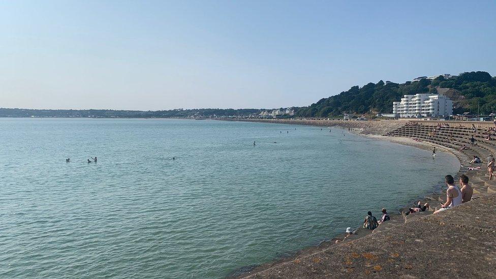 People swimming in bay in Jersey