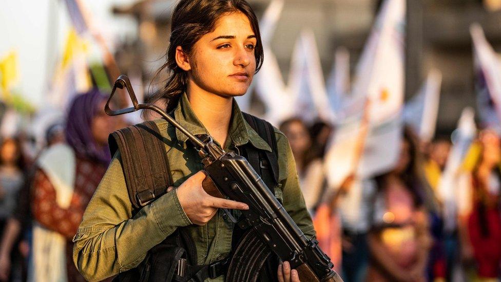 A member of the Syrian Kurdish internal security forces stands guard as Kurds protest in Qasmishli against Turkish threats to launch an offensive on northern Syria (27 August 2019)