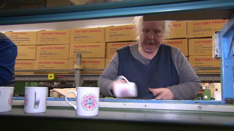 A worker packing away some of the mugs in Liverpool