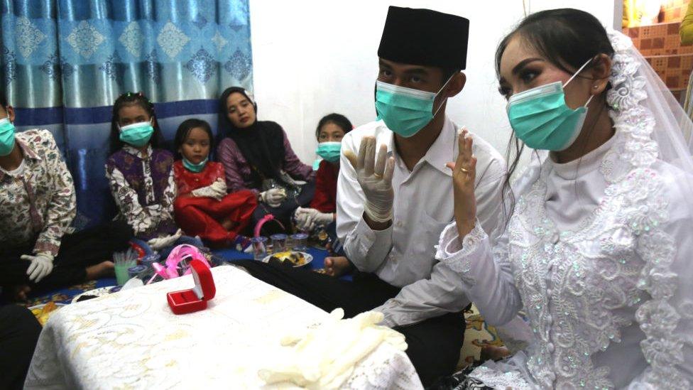 Couple wearing protective masks gets married.