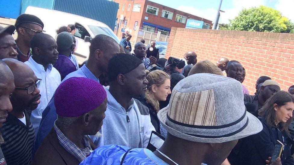 Family and friends gather to listen to a press conference at the scene