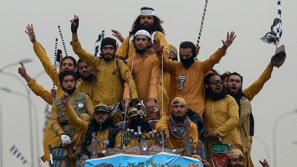 Supporters of the Islamist Jamiat Ulema-e-Islam (JUI-F) wave party flags atop a vehicle as they take part in an anti-government "Azadi (Freedom) March" towards Islamabad, from Peshawar on October 31, 2019