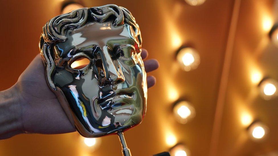 A photo of a Bafta award, which is an awards trophy in the shape of a person's face.