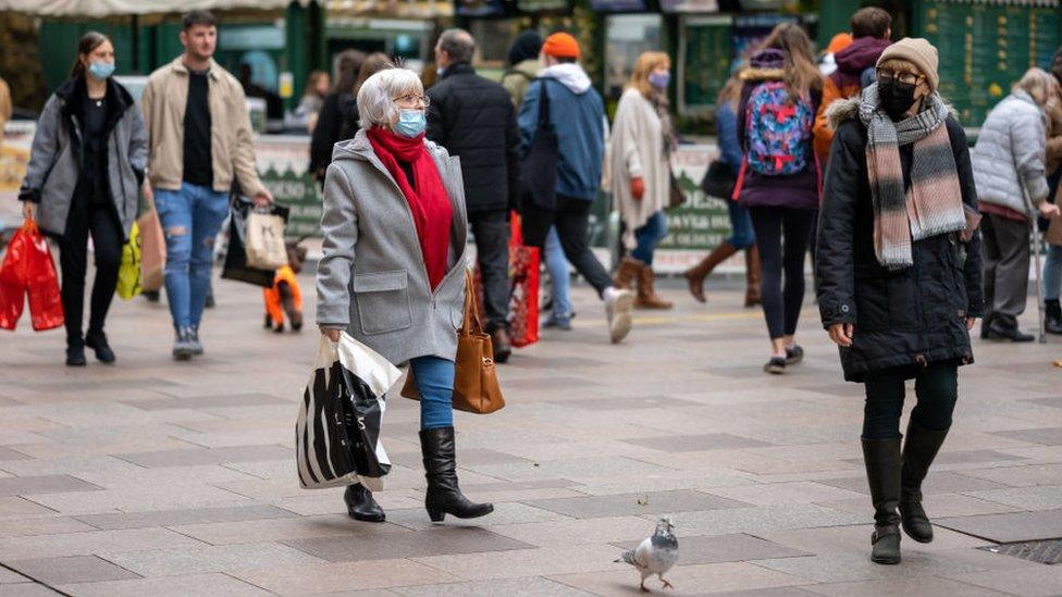 Two women walking through Cardiff wearing face masks