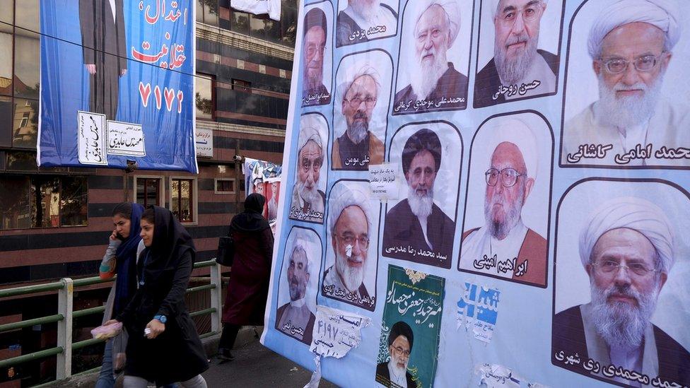 Women walk past candidates for the Assembly of Experts in Tehran, Iran (24 February 2016)