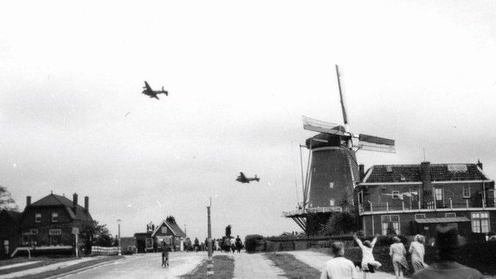 Lancaster bombers flying past a windmill