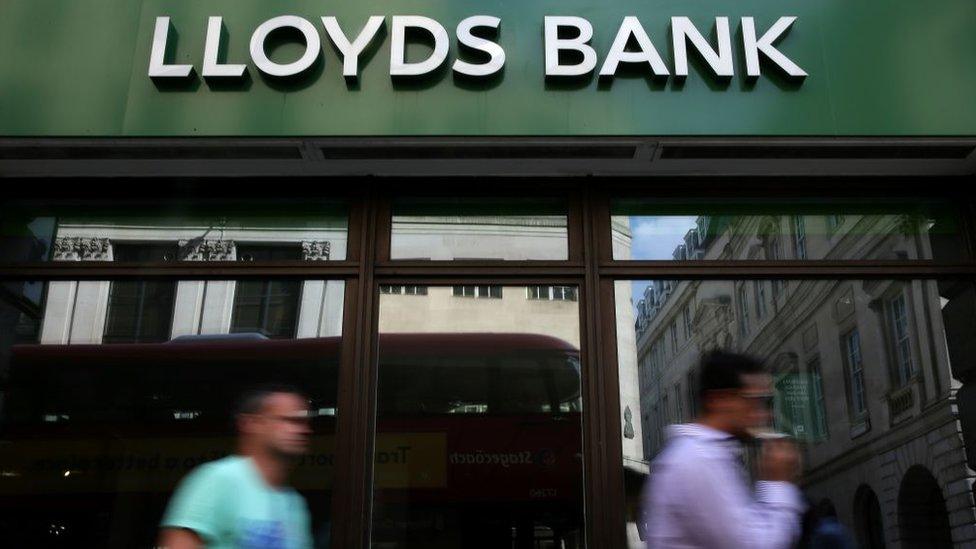 People walk past Lloyds bank branch