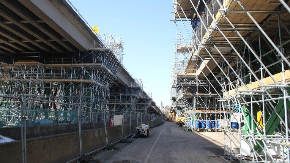 A shot from the base of the viaducts, with scaffolding covering the supporting pillars. Taken on a sunny day.