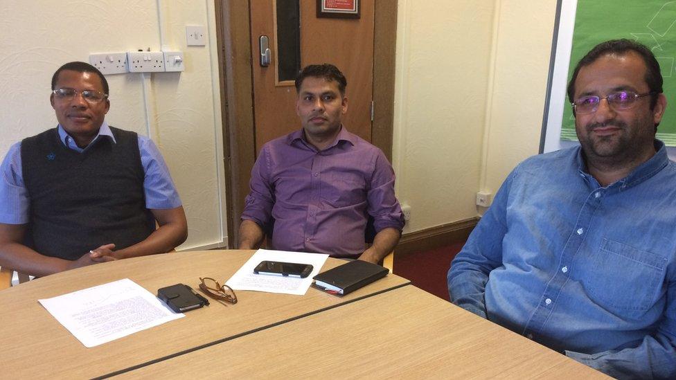 Refugee doctors sitting around a table in their English class