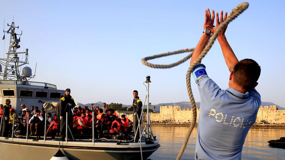 Frontex officer grabs a rope during an rescue mission off a Greek island in 2015