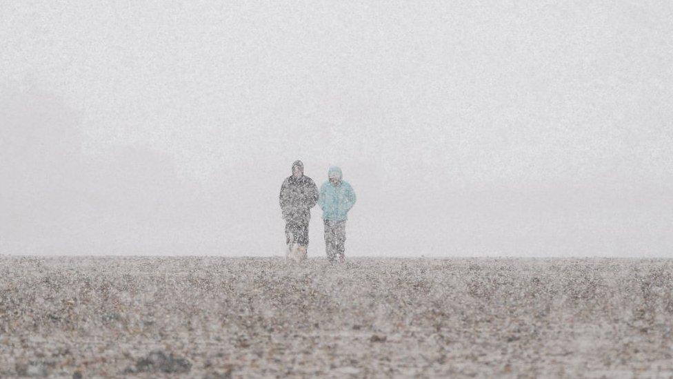 A couple walk along Redcar beach