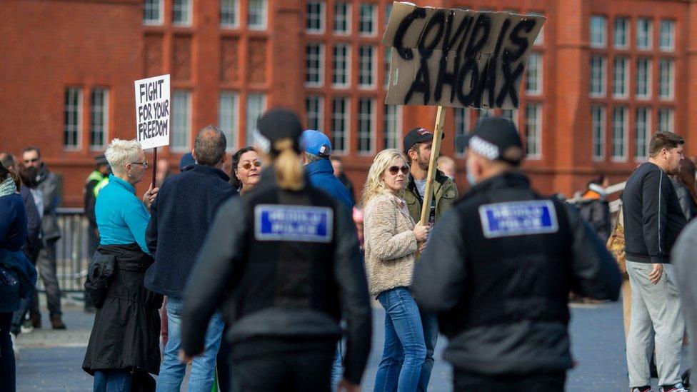 Swyddogion heddlu mewn protest yn erbyn y cyfyngiadau Covid ym Mae Caerdydd y llynedd