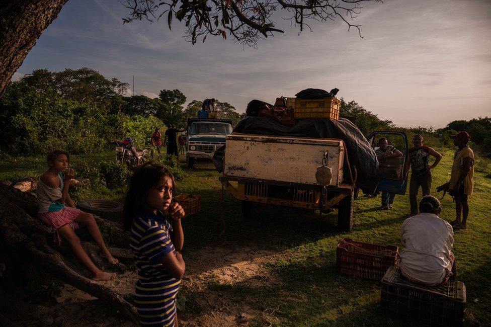 Two girls wait for fishermen to return with the catch