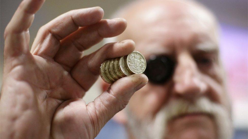 Royal Mint press setter holds up coins